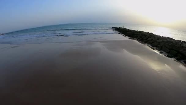 空中记录俯瞰地平线 海浪突破防波堤 地中海 日落在海滩上与五颜六色的天空 低潮在圣玛丽亚 基齐兹 安达卢西亚港 — 图库视频影像