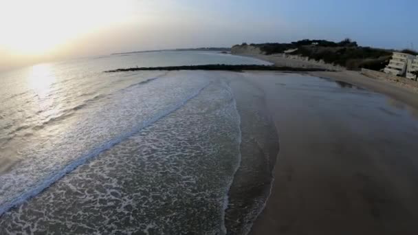 空中记录俯瞰地平线 海浪突破防波堤 地中海 日落在海滩上与五颜六色的天空 低潮在圣玛丽亚 基齐兹 安达卢西亚港 — 图库视频影像