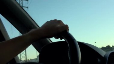 4k. Ultra Hd. Arabayı kullanan direksiyondaki kişinin ellerini yakın çekim. Önünde gün ışığı olan bir araç kullanan kadın. İşe giderken. Kadınların elleri. Teknoloji ve ulaşım