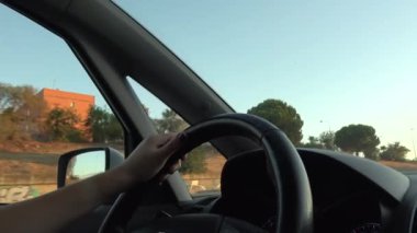 4k. Ultra Hd. Arabayı kullanan direksiyondaki kişinin ellerini yakın çekim. Önünde gün ışığı olan bir araç kullanan kadın. İşe giderken. Kadınların elleri. Teknoloji ve ulaşım