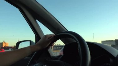 4k. Ultra Hd. Arabayı kullanan direksiyondaki kişinin ellerini yakın çekim. Önünde gün ışığı olan bir araç kullanan kadın. İşe giderken. Kadınların elleri. Teknoloji ve ulaşım