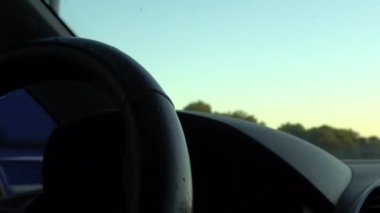 4k. Ultra Hd. Arabayı kullanan direksiyondaki kişinin ellerini yakın çekim. Önünde gün ışığı olan bir araç kullanan kadın. İşe giderken. Kadınların elleri. Teknoloji ve ulaşım