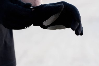 Bisiklete binmeye hazırlanan adam. Beyaz bir adam bisiklete binmek için eldiven takıyor. Harika bir gün batımı ve doğal bir arka plan altında. Spor.