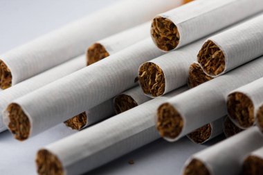 Beyaz arka planda izole edilmiş çok sayıda sigara. Tütün organizmada hastalıklara neden olabilir. Sigara içmek vücudunuza zarar verir.