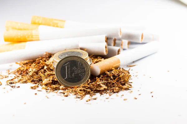 Tabaco desfiado com moedas de euro à volta, isolado sobre fundo branco. O tabaco pode causar doenças no organismo . — Fotografia de Stock