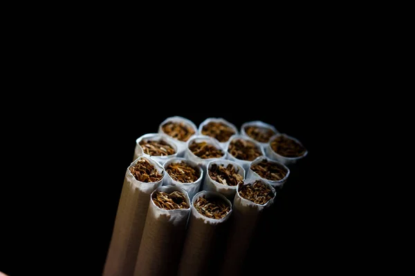 Numerosos cigarros isolados em fundo preto. O tabaco pode causar doenças no organismo. Fumar dói seu corpo . — Fotografia de Stock