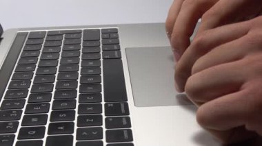 Bir adam dizüstü bilgisayar kullanıyor. Parmaklarınızın trackpad'de hareket ettirilmesi. Dizüstü bilgisayardaki dosyaları yönetme.