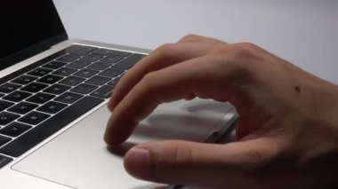 Bir adam dizüstü bilgisayar kullanıyor. Parmaklarınızın trackpad'de hareket ettirilmesi. Dizüstü bilgisayardaki dosyaları yönetme.