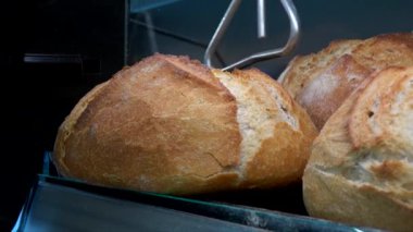 Hd. Yakın kapat genç beyaz kadın ekmek almak için fırından toplar. Genç kadın süpermarketin fırınından ekmek topluyor.