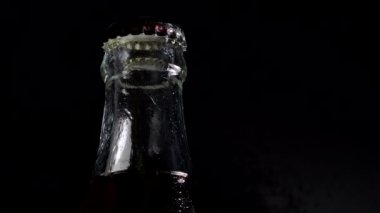 4k. Ultra Hd. Bir soda şişesi aşağı yuvarlanan yoğuşma damlaları. Siyah bir arka plan üzerinde. Şeffaf soda şişesi. ıslak.
