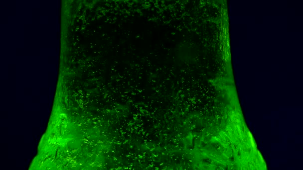 凝縮はソーダボトルを転がり落ちる ボトル内のガスの泡 黒い背景に緑のソーダのボトル ウェット — ストック動画