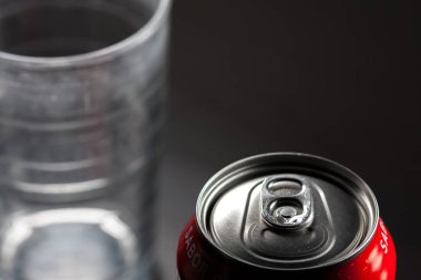 Yanında bir bardak olan soğuk açılmamış soda. Aşırı şekerli soğuk meşrubatlar, kapalı. Sağlıklı değil. Soğuk içecekler.