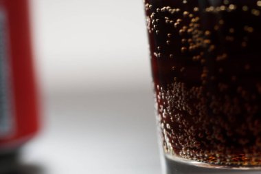 Cam bardakta servis edilen alkolsüz içecek. Sıvı yüzeye kafein ve gaz sıçraması. Aşırı şekerli soğuk meşrubatlar. Sağlıklı değil. Soğuk içecekler.