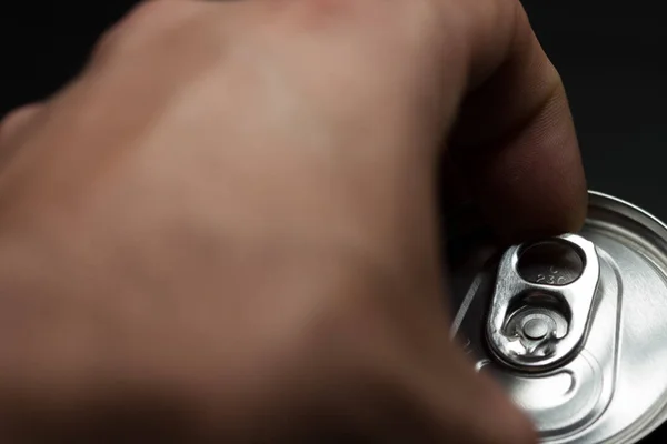 Hand opening a can of cold soda. Finger making strength to open the can. Cold drinks.
