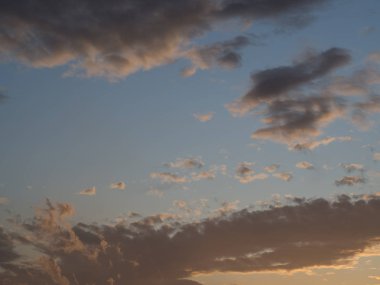 Şiddetli bir yağmur fırtınasından önce. Açık güneş ışığının göründüğü turuncu gün batımı. Gökyüzü bulutlarla kaplıdır, açık mavi gökyüzü ile. Kara bulutlar.