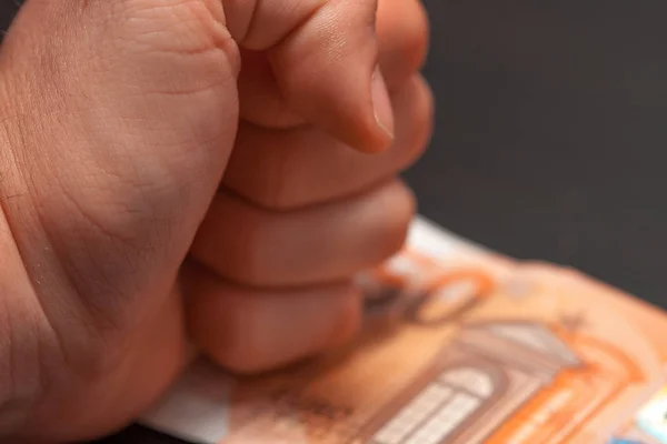 Close up of businessman hand hitting his fist angrily on top of fifty euro bills, on table problems. On top of euro banknotes, stress, desk in the workplace office