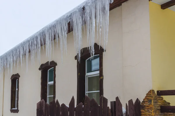 氷の家の屋根の端に形成 つらら — ストック写真