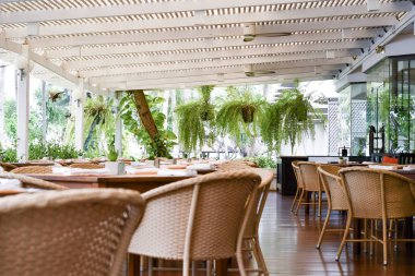 Tatilde tatil beldelerinin kahvaltı salonunda masa ve sandalyeler. 