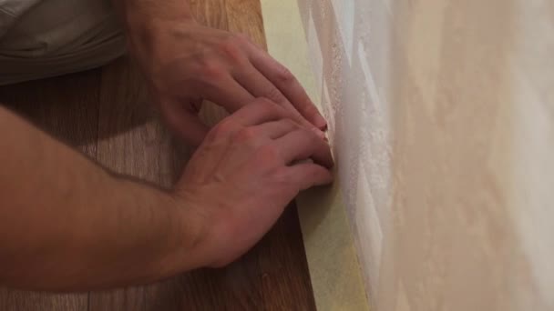 Caucasian man glues masking tape on wall plinth to protect against contamination — Stock Footage Caucasian man glues masking tape on wall plinth to protect against contamination Stock Footage
