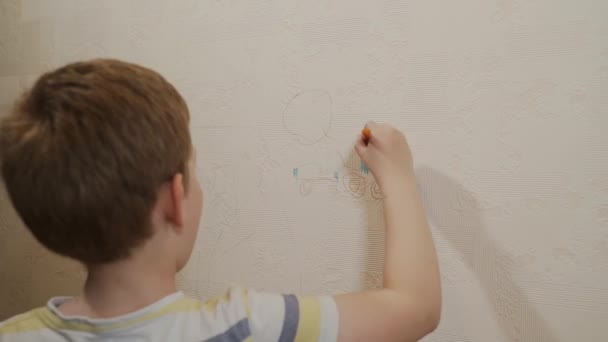 Caucasian boy draws with a marker, felt-tip pen the sun on the wallpaper — Stock Footage Caucasian boy draws with a marker, felt-tip pen the sun on the wallpaper Video Clip