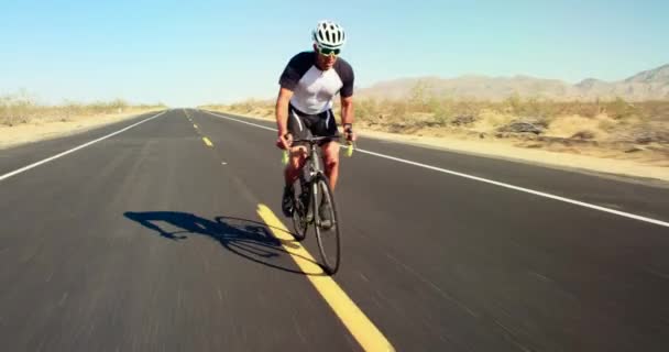在阳光明媚的日子 在沙漠公路外骑自行车骑车的年轻人 — 图库视频影像