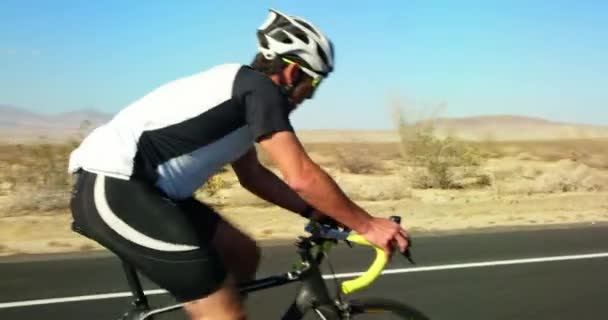 Young Man Cycling Road Bike Desert Road Sunny Day — Stock Video