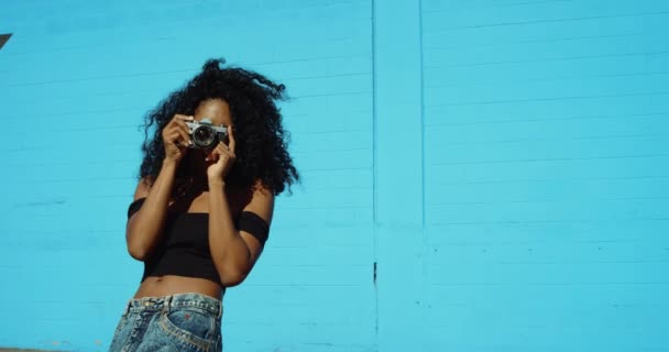 Mujer Joven Disparando Fotos Con Cámara Película Contra Colorida Pared — Vídeo de stock