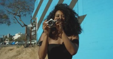 Afrikalı-Amerikalı kadın film kamerası ve çekici fotoğraflar ile oynarken yavaş çekim