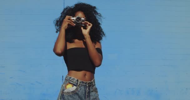 Mujer Joven Disparando Fotos Con Cámara Película Contra Colorida Pared — Vídeo de stock