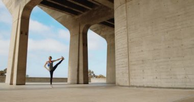 Taş köprü altında Yoga egzersiz yaparak genç güçlü kadın