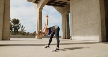 Taş köprü altında Yoga egzersiz yaparak genç güçlü kadın