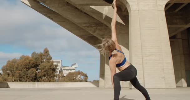 Νέα Ισχυρή Γυναίκα Κάνει Γιόγκα Άσκηση Από Πέτρινο Γεφύρι — Αρχείο Βίντεο