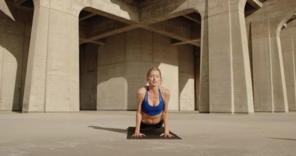 Νέα Ισχυρή Γυναίκα Κάνει Γιόγκα Άσκηση Από Πέτρινο Γεφύρι — Αρχείο Βίντεο