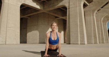 Taş köprü altında Yoga egzersiz yaparak genç güçlü kadın