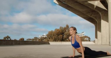 Taş köprü altında Yoga egzersiz yaparak genç güçlü kadın