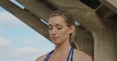 Genç kadın taş köprü altında meditasyon