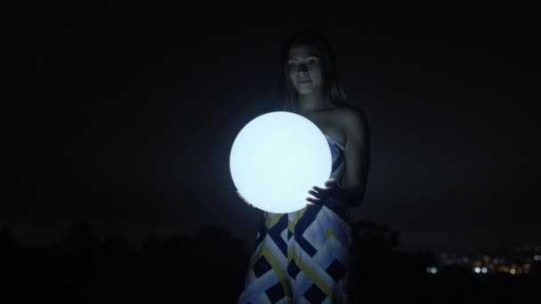 Młoda Kobieta Trzymając Piłkę Świecące Ciemności — Wideo stockowe