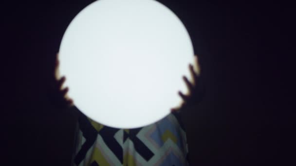 暗闇の中で光るボールを保持している若い女性 — ストック動画