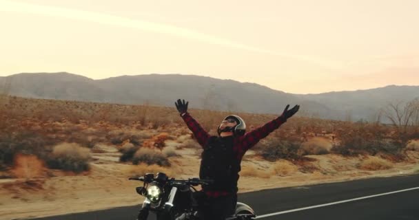 Junger Mann Fährt Schwarzes Oldtimer Motorrad Bei Sonnenuntergang Die Wüstenautobahn — Stockvideo