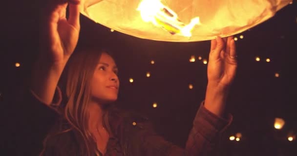 愉快的年轻妇女在晚上点燃纸灯笼在元宵节期间 — 图库视频影像