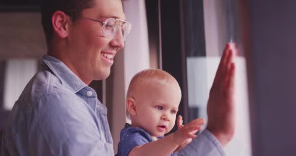 Young Father Curious Baby Girl Looking Out Glass Window Apartment — 图库视频影像