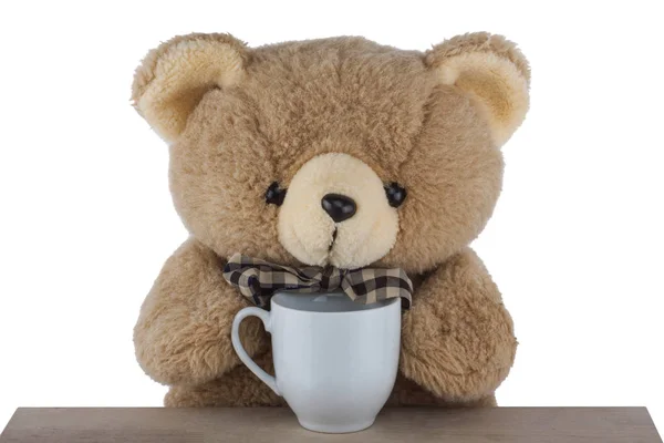 Плюшевий ведмідь п'є чай на столі ізольовано на білому фоні — стокове фото