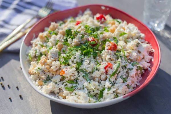 Çiğ karnabahar salatası roka, nohut, küçük domates ve mayonez, masada..