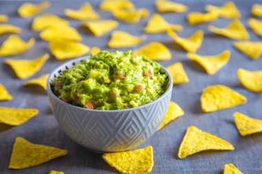Ev yapımı guacamole sosu seramik kasede mısır cipsi ve cips..