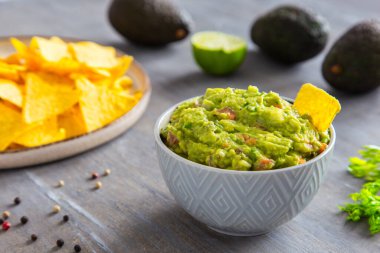 Ev yapımı guacamole sosu seramik kasede mısır cipsi ve cips..