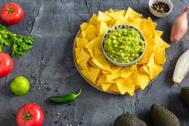 Ev yapımı guacamole sosu seramik kasede mısır cipsi ve cips..