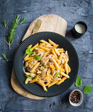 Siyah tabakta mantarlı makarna ve siyah bir arka plan..