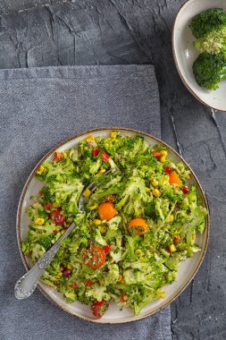 Çiğ brokoliden yapılmış sağlıklı salata, kırmızı biber ve mısır, düşük kalori diyeti.