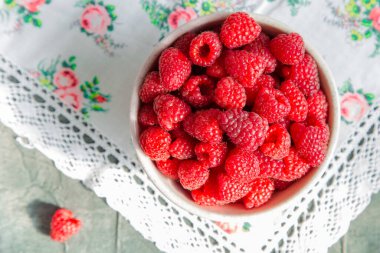 Masadaki seramik kasede taze ahududu, kırsal atmosfer..