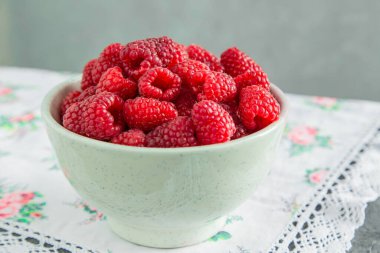 Masadaki seramik kasede taze ahududu, kırsal atmosfer..